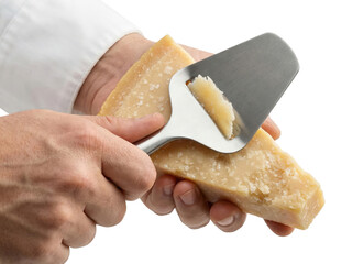 Chef hands shaving hard parmesan cheese wedge with metal slicer