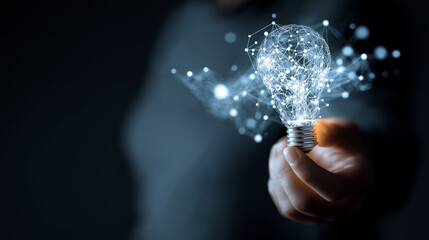 Hand holding glowing digital light bulb symbolizing innovation