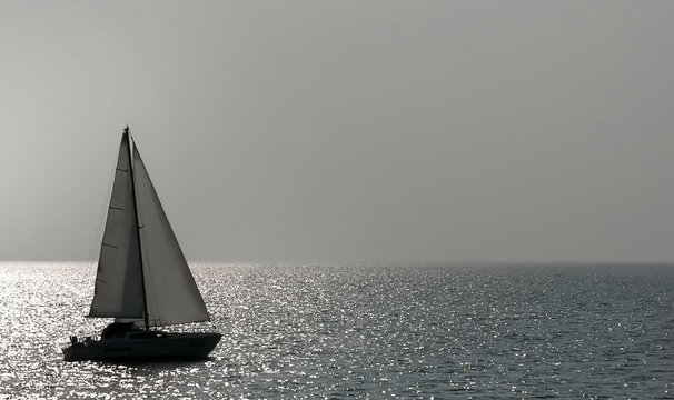 A sailboat gliding through calm ocean waters