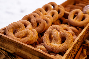 Close-Up of Traditional Sugar-Covered Heart-Shaped Pretzels in Wooden Box at Outdoor Winter Market