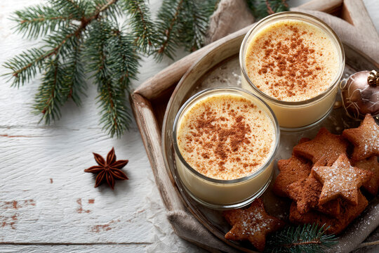 Eggnog Christmas milk cocktail with cinnamon, served in two glasses on vintage tray with shortbread star shape sugar cookies - Powered by Adobe