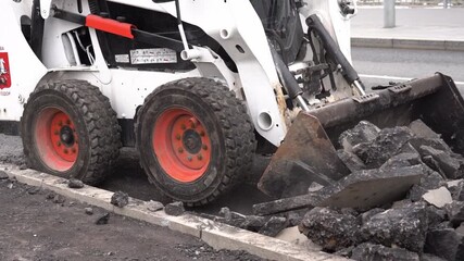 Moscow, December 01 2025, construction site with a large machine scooping up rocks. The scene is dark and gloomy, with the rocks scattered all over the ground