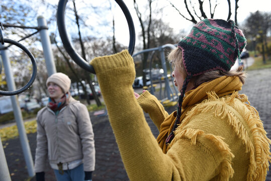 Mother and daughter using gymnastic rings in outdoor gym park