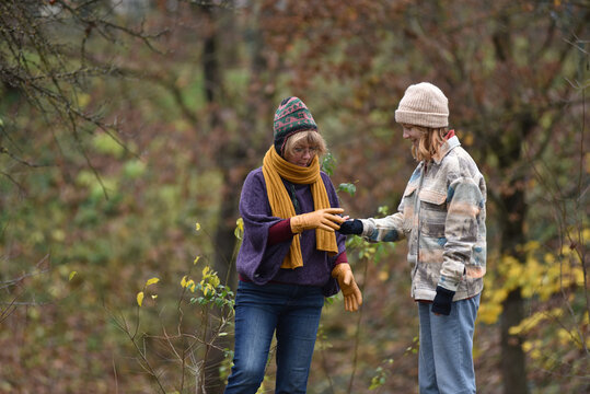 Mother and teenager daughter walking and interacting in an autumn park