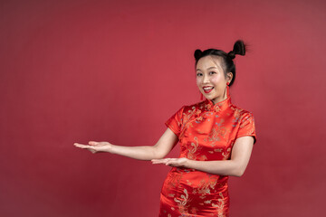 Friendly Chinese female gesturing to side for Lunar New Year advertisement