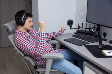 Man wearing headphones and smiling enjoying music in home studio or office