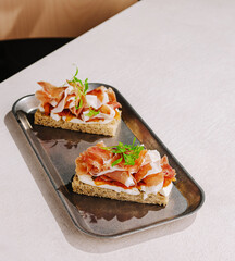 Delicious open-faced sandwiches with toppings on a modern tray