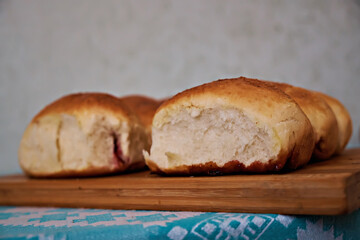 Homemade freshly baked soft buns with filling, close-up, on a baking sheet held by a woman. Selective focus. Close-up
