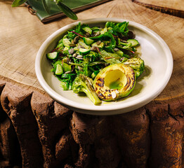 Fresh salad with grilled vegetables on a wooden table in a cozy setting
