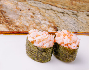 Delicious sushi rolls made with shrimp and seaweed on a marble surface