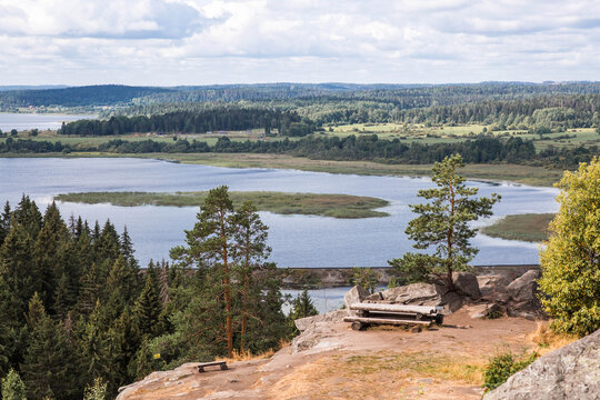 Panoramic view from the top of the cliff to the lake surrounded by forests and fields. Viewpoint in Sortavala. Nature of the Republic of Karelia. North.