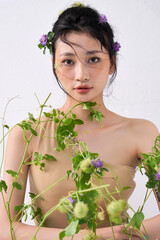 Side profile of the woman with floral elements in her hair, gazing downward.