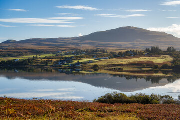 Scottish highlands village reflecting in a calm loch
