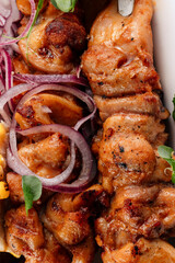 Juicy grilled chicken kebabs on skewers, perfectly cooked with a golden, charred surface, served as a flavorful main course with fresh herbs and spices.