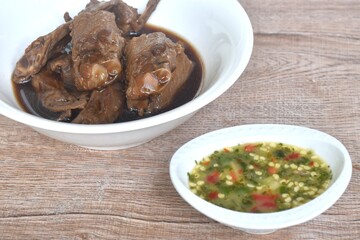 chop boiled duck wing stew in brown soy soup on bowl dipping spicy sour chili sauce 