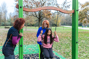 Family enjoying playful swing time in autumn park