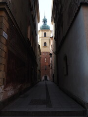Ciemna uliczka z widokiem na wieżę kościoła