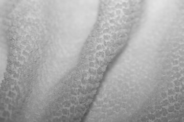 Extreme closeup of a fresh white terry cloth towel. Soft, fluffy texture with gentle folds. Perfect background for spa, cleanliness, or wellness concepts.