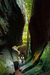 Photographer setting up camera on tripod in dramatic cave lighting