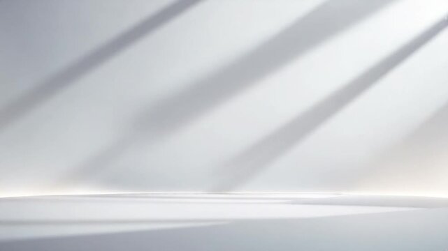 Minimalistic studio scene with soft natural light casting shadows across a smooth white surface creating an elegant backdrop for various objects in a tranquil indoor environment