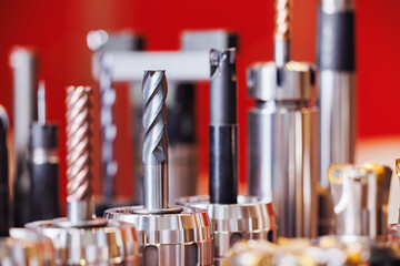 Close-up of cnc machine cutting tools on red background for precision engineering