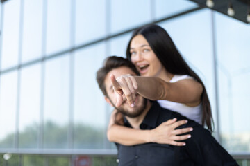 Man pointing at woman in heated discussion in city park setting.