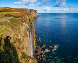 Kilt rock waterfall cascading down basalt cliffs into ocean