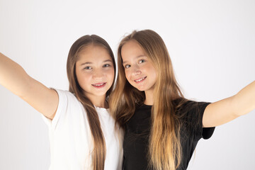 The two girls i are smiling and taking a selfie.