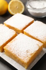 Tasty lemon bars with powdered sugar on grey table, closeup