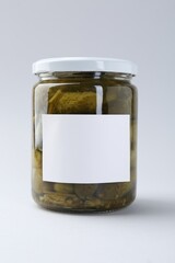 Pickled cucumbers in jar on light background, closeup
