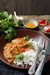 Chicken tikka masala with rice served on wooden table, closeup