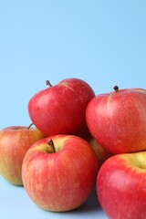 Ripe red apples on light blue background, closeup