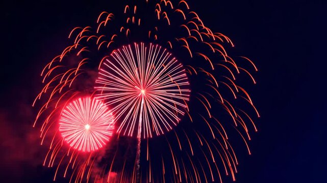Spectacular display of vibrant red fireworks exploding in a night sky showcasing a series of colorful bursts and shapes from beginning to end against a dark backdrop with smoky textures