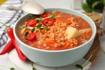 Delicious lentil soup with vegetables served on table, closeup