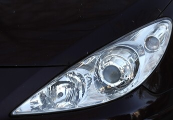 Close-up of the front left headlight on a black car