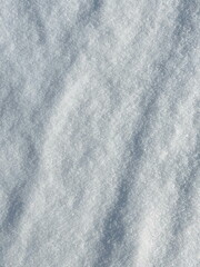 Detailed view of smooth snow surface with natural winter shadows.