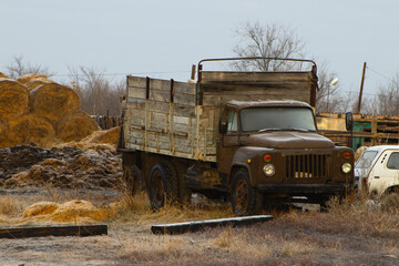 Weathered Brown Vintage Flatbed Truck with Wooden Sides Parked in a Field
