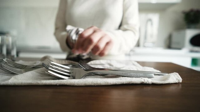 Girl Wiping Dry The Clean Washed Forks And Cutlery In A Light Kitchen