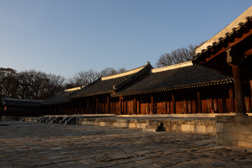Fototapeta premium Editorial use only. Seoul, South Korea – November 22, 2025: Visitors walking across the courtyard of Jongmyo Shrine, a UNESCO World Heritage site, showing the long traditional hall and autumn trees.