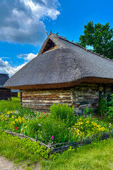 Green summer colors light up the countryside among old wooden houses and ancient churches in Ukraine, creating a warm nostalgic atmosphere.
