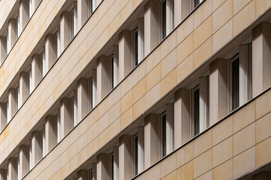 A modern architecture composition uniting facade repetition and pattern forms as geometry aligns with background tones and contrast to reinforce a structure guided by abstract design and urban texture