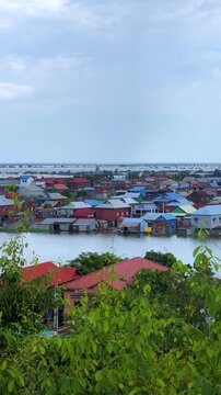 Viewpoint of a flooded fishing village near the Krahom Temple, Cambodia. From the mountain Krahom (Pnom Krom) overlooking the lake Tonlesap. Houses are built on high stilts. Rainy season. 4К
