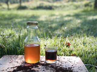 Making fresh coffee mixed with wild honey in a black coffee pot on the grass in the warm morning light.