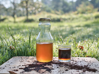 Making fresh coffee mixed with wild honey in a black coffee pot on the grass in the warm morning light.