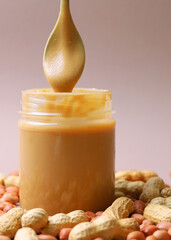 peanut butter and raw peanuts on a light background. Vertical photo format