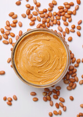 peanut butter and raw peanuts on a light background. Vertical photo format