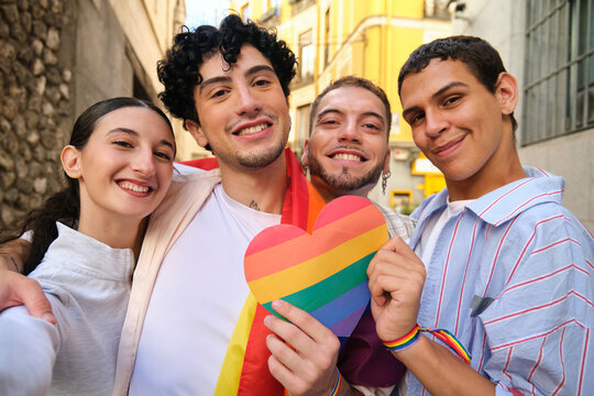 Smiling diverse friends posing for a selfie during pride festival - Powered by Adobe