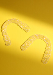 Aligners for straightening teeth on a light background. Vertical photo format