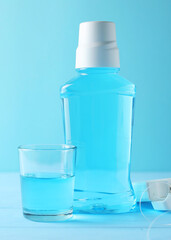 A mouthwash on a colored background. Dental care, dental health. Vertical photo format