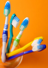 Different toothbrushes on a colored background. Dental care, oral health. Vertical photo format